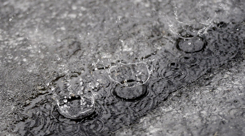 Raindrops splash along a drip line on an icy driveway in Saco on Monday.