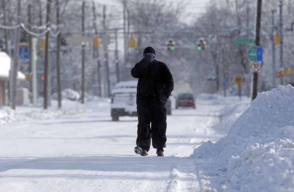 A pedestrian makes his way along a snow packed street in Indianapolis Monday as temperatures hovered around 10 below zero. More than 12 inches of snow fell on Sunday.