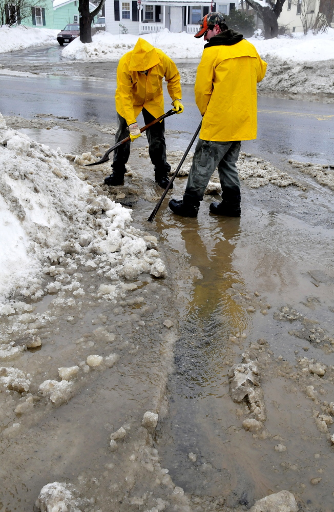 UNPLUGGED: Waterville Parks and Recreation Department employees Steve Buzzell, left, and Sam Green were reassigned Monday to help the city Public Works Department clear storm drains in Waterville.