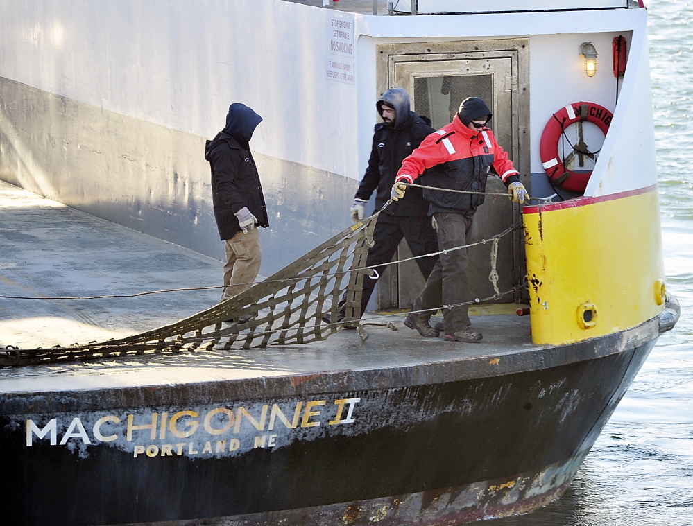 Crew members of the Machigonne II put up a safety barrier in the cold weather as the ferry leaves from the Casco Bay Lines terminal for the islands on Tuesday.