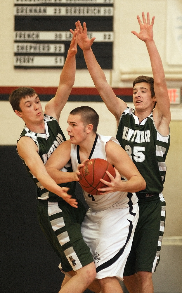 Staff photo by Joe Phelan Hall-Dale's Brandyn Bechard, middle, is double-teamed by Winthrop's Ben Allen, left, and Dakota Carter during a game on Tuesday January 7, 2014 in the Penny Memorial Gymnasium at Hall-Dale High School in Farmingdale.