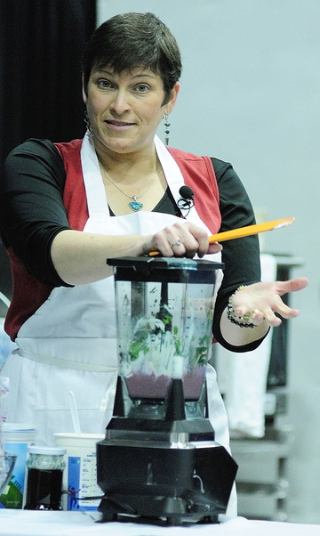 AG SHOW: Cynthia Finnemore Simonds, of Mindful Mouthful, talks about making smoothies featuring kale and blueberries during a cooking demonstration at the Maine Agricultural Trades Show on Wednesday at the Augusta Civic Center.
