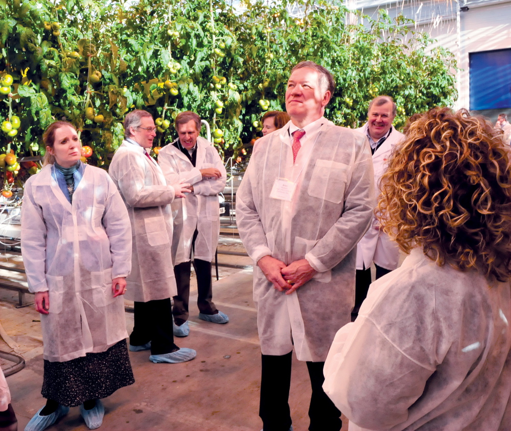 WE’RE BACK: Backyard Farms employee Erika Verrier, center, speaks with officials including Brian Mulligan of the Maine Department of Economic and Community Development, second from right, during a tour at the Madison facility on Wednesday. The company is back in operation after a six-month shutdown because of a white fly infestation.