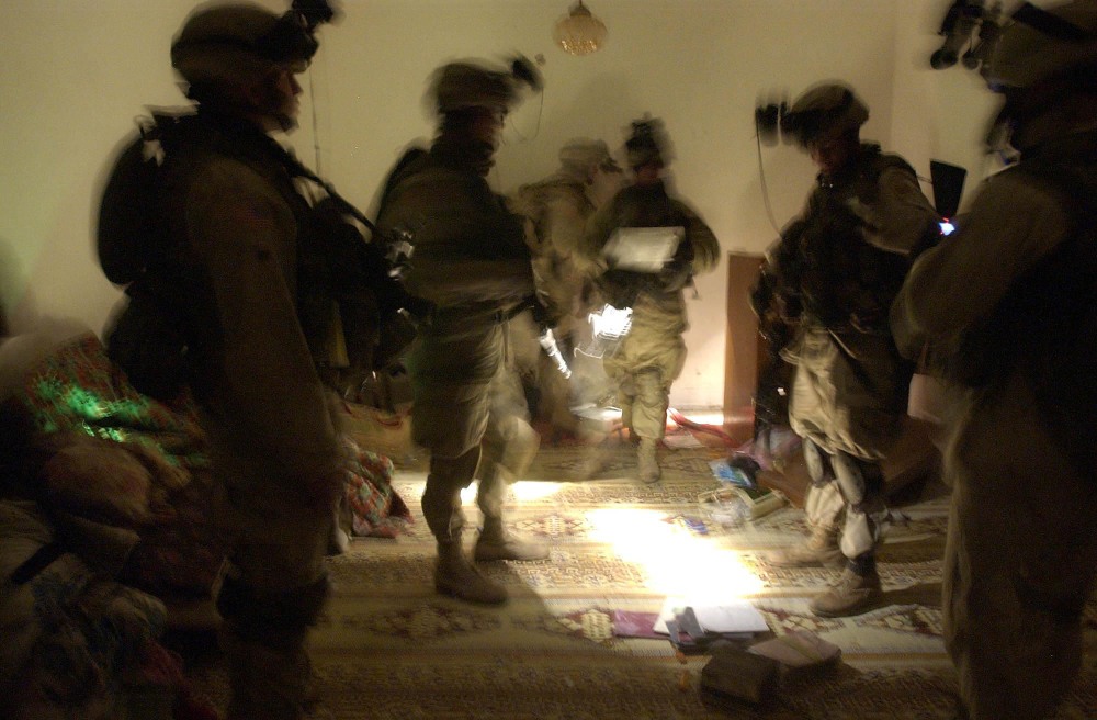 FILE - In this Wednesday, Jan. 14, 2004 file photo, soldiers with the 82nd Airborne Division spread out documents and other objects on the floor while looking for evidence during a raid on an Iraqi house near Fallujah, Iraq. The owner of the house is suspected of being responsible for attacks on coalition forces. In 2014, the city’s fall to al-Qaida-linked forces has touched a nerve for the service members who fought and bled there.