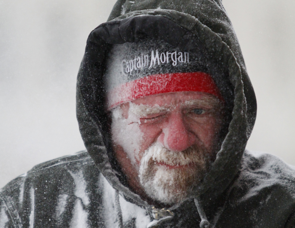 Allan Umscheid, owner of Yards By Al, feels the bitter wind and catches drifting snow on his face as he runs a snowblower in Lawrence, Kan., on Sunday.