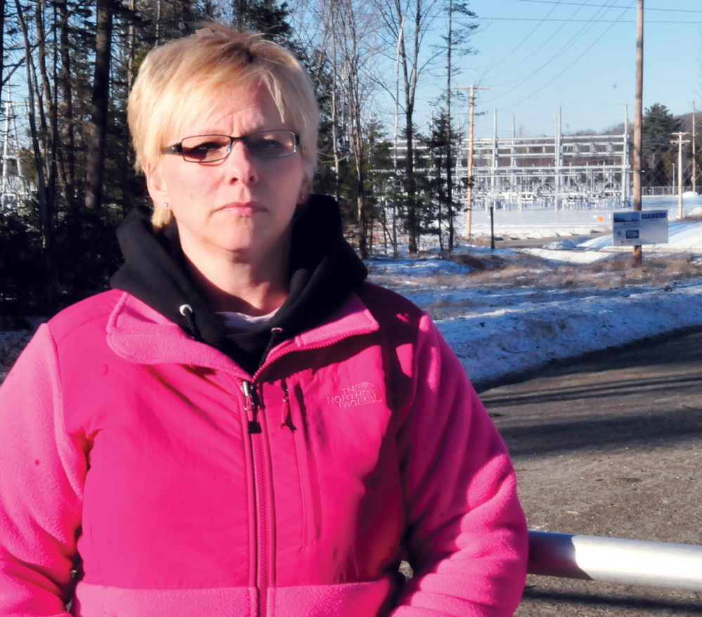 QUIET PLEASE: Benton resident Sue Blaisdell stands at the gate to the CMP substation near her home off the Albion Road on Thursday. Blaisdell and other neighbors have complained about noise levels coming from the substation.
