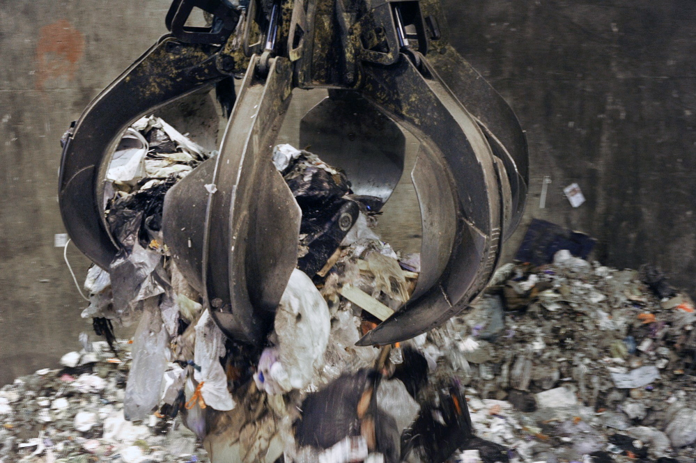 A bucket loader moves trash at ecomaine’s processing facility in Portland.
