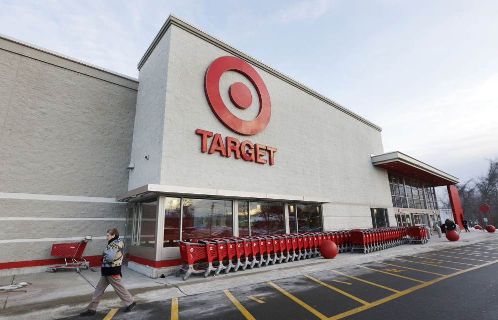 In this Dec. 19, 2013, file photo, a passer-by walks near an entrance to a Target retail store in Watertown, Mass. Target says that personal information ó including phone numbers and email and mailing addresses ó was stolen from as many as 70 million customers in its pre-Christmas data breach.