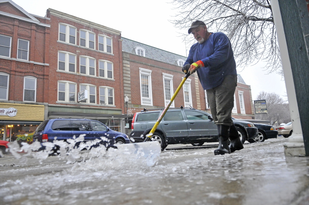 ICE WORK: Bruce Heath, with KB Property Care, clears the sidewalks Saturday on Main Street in Waterville. More ice has covered central Maine, making travel a dangerous adventure.