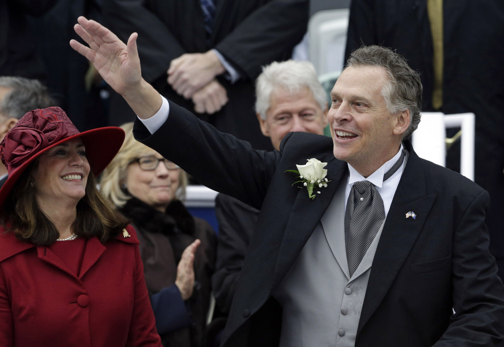 Virginia Gov. Terry McAuliffe, right, waves to supporters alongside his wife Dorothy during inaugural ceremonies at the Capitol in Richmond, Va. on Saturday. Former U.S. Secretary of State Hillary Rodham Clinton, left, and former U.S. President Bill Clinton look on in the background. McAuliffe is the 72nd governor of Virginia.