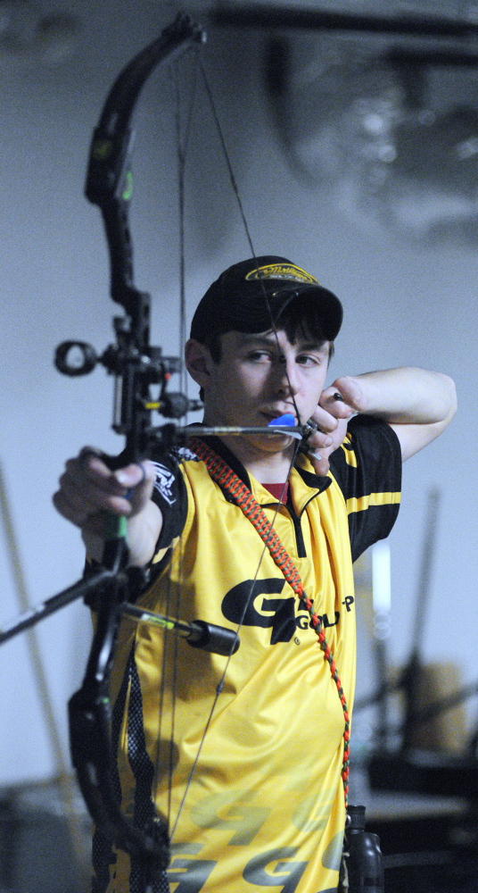 SHOOTING PRACTICE: Charlie Weinstein, 17, practices archery on Thursday in a storage room at Maranacook Community Middle School in Readfield.