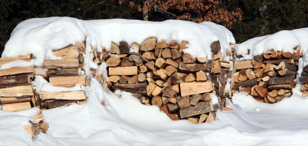 Stacks of wood are seen at the town transfer station in Hopkinton, N.H. Like a food bank, several communities in northern New England run by church groups, social services agencies and towns, have set up wood piles for needy residents to get wood through the cold winters. (AP Photo/Jim Cole)