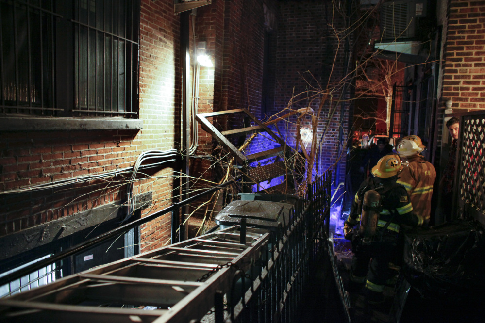 Firefighters gather in an alley after a fire escape landing collapsed in the Rittenhouse Square section of Philadelphia early Sunday morning.