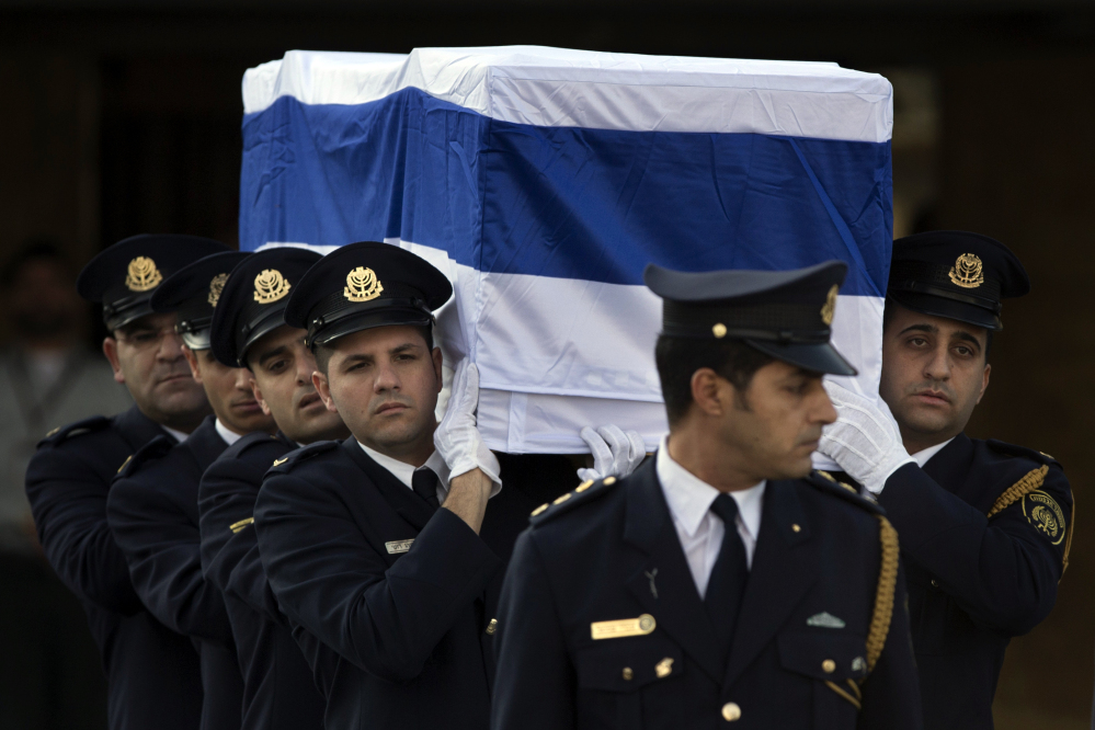 Members of the Knesset guard carry the coffin of late Israeli Prime Minister Ariel Sharon at the Knesset Plaza in Jerusalem on Monday. The ceremony was to be followed by a private burial on the family’s desert ranch in southern Israel.