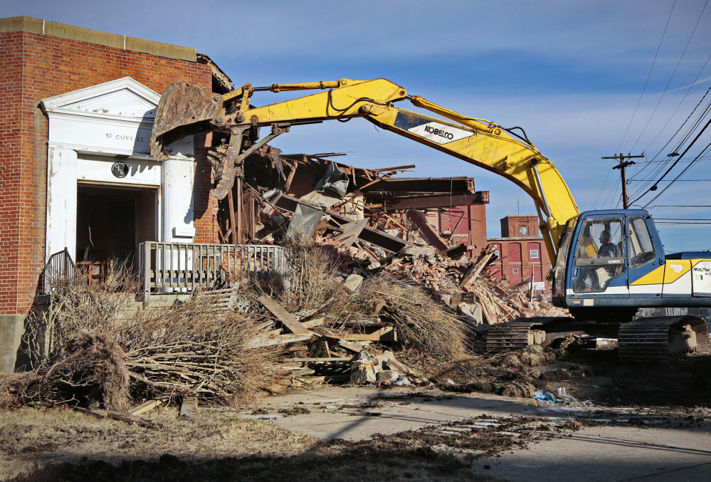 An excavator operator demolishes the entrance to the former headquarters of the Berkshire Hathaway mill, where investor Warren Buffett first made his mark, in New Bedford, Mass.
