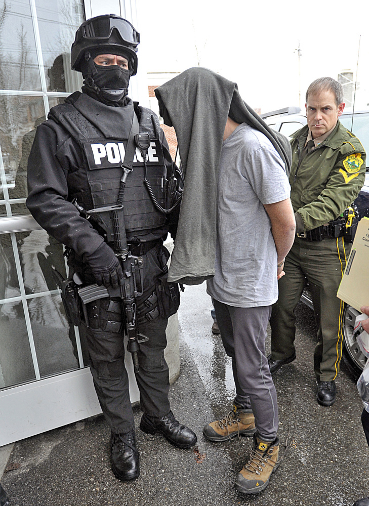 A suspect is taken into custody on Jan. 16, 2013, in Bennington, Vt., one of dozens of suspects rounded up in southwestern Vermont on charges related to the distribution and sale of illicit drugs.