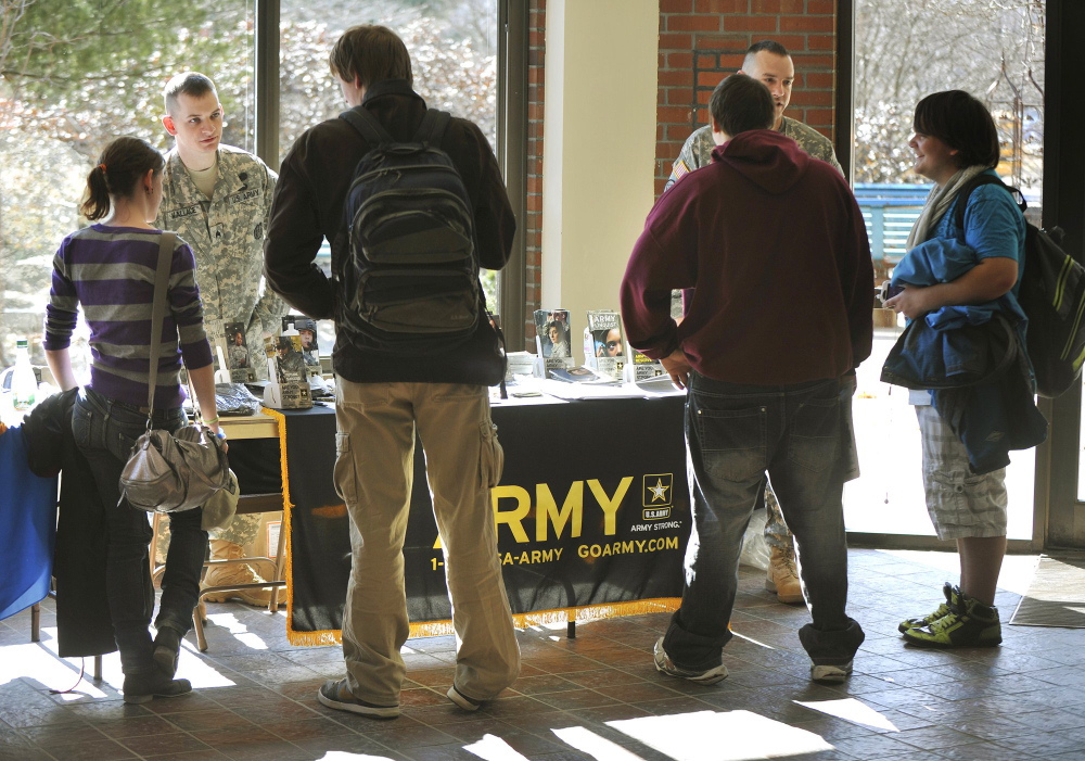 Army recruiters Sgt. Stephen Wallace, left, and Sgt. 1st Class Brandon Didier talk with Portland Arts and Technology High School students during a 2012 job fair. A proposal that would ensure that recruiters are allowed to wear uniforms while visiting schools was approved by a state legislative committee Wednesday.
