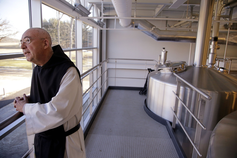 Spencer Brewery Director Father Isaac stands near the top of the facility’s fermentation tanks and looks out a window onto the abbey’s grounds in Spencer, Mass. Father Isaac was a potter before joining the Trappist community 35 years ago. He is one of 25 priests living in a community of 63 monks at St. Joseph’s.