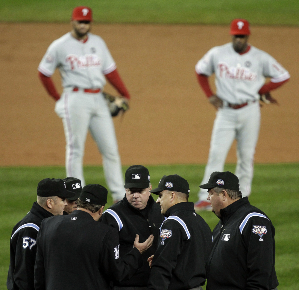 AP Photo/Julie Jacobson In this Oct. 28, 2009, file photo, Philadelphia Phillies’ Pedro Feliz, left, and Jimmy Rollins watch in the background, as umpires discuss a call at first base during the Game 1 of the World Series. Major League Baseball announced Thursday, Jan. 16, 2014, that it will greatly expand instant replay to review close calls starting this season.