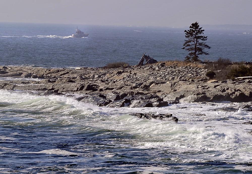 A boat cruises by Kresge Point near Pemaquid Point, where searchers looked for survivors of a reported sailboat sinking Friday.