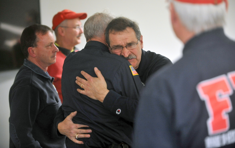 goodbye: Capt. Richard Knight, facing right center, hugs Clyde Ross at his retirement party at the Farmington fire station on Friday. Knight served the Farmington community as a firefighter for 35 years.