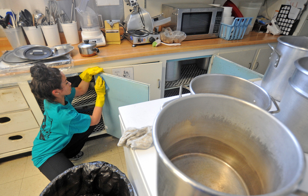 CLEAN GETAWAY: Colby College freshman Jaritza Abreu, 18, scrubs cabinets in memory of Martin Luther King Jr. on Saturday in the Universalist Unitarian Church kitchen in Waterville.