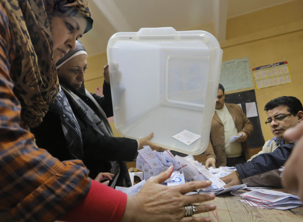Egyptian election workers empty a ballot box in Cairo on Wednesday, the second and final day of a referendum on a new constitution. Four people were killed in clashes Friday.