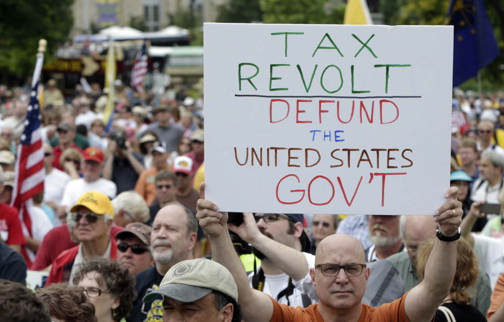 A man holds up a placard during a tea party rally at the U.S. Capitol in Washington in June. As both parties gear up for a midterm election campaign season that will determine the control of Congress, the Republican agenda is at a crossroads.