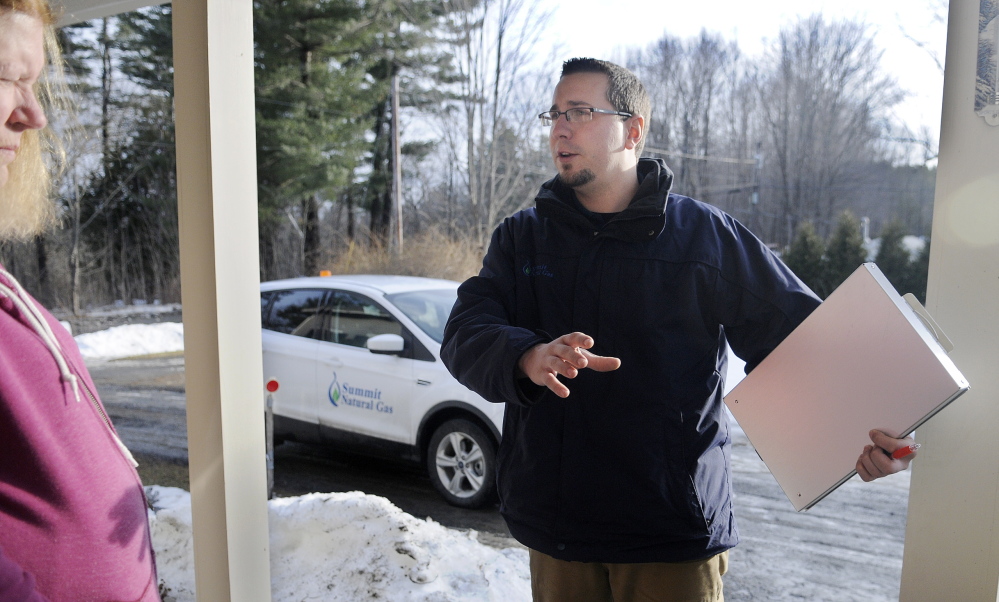 COLD CALL: Summit Natural Gas of Maine salesman Nick Snowdeal speaks Wednesday with Hallowell home owner Cindy Lockwood about the location of a distribution line the company is hoping to install near her home. The arrival in 2013 of natural gas firms installing underground pipes in the Kennebec Valley has strained the resources of communities and utilities.