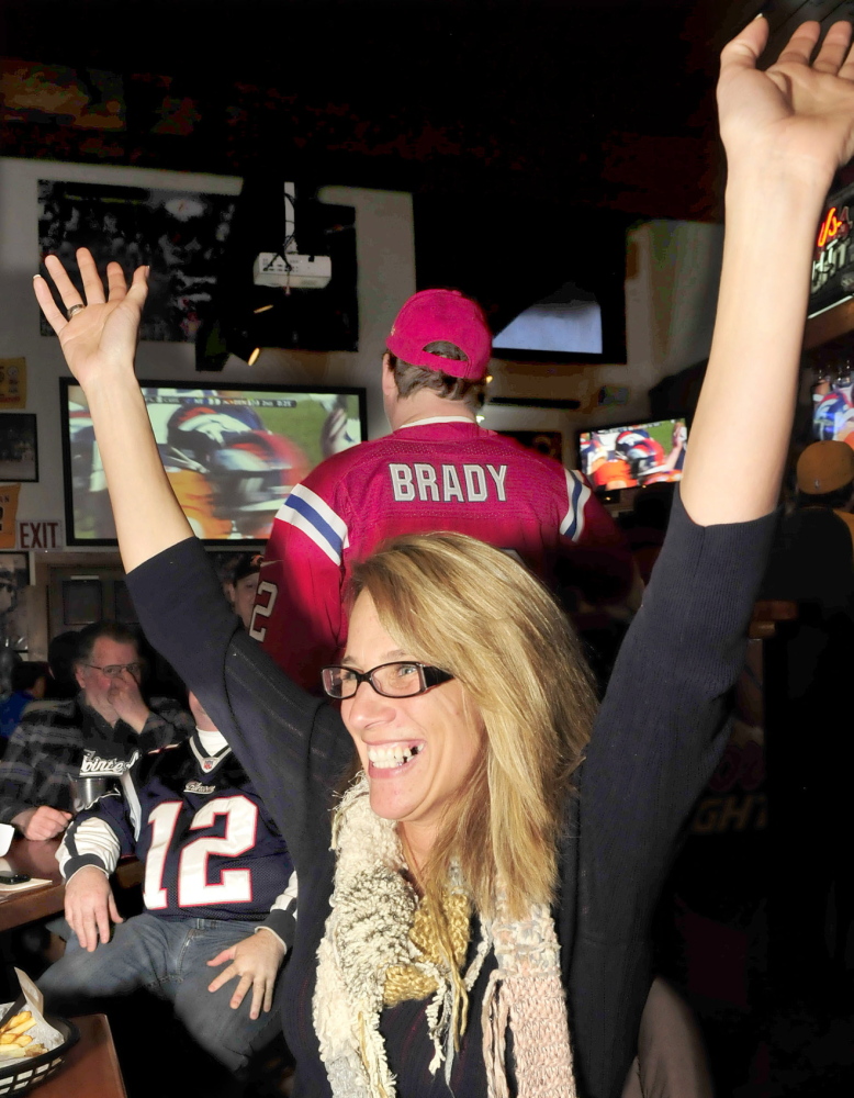 Staff photo by David Leaming MINORITY: Denver Broncos fan Debbie Patterson reacts to a field goal by her team while surrounded by New England Patriots fans during AFC championship game at the Pointe Afta in Winslow on Sunday, Jan. 19, 2014.