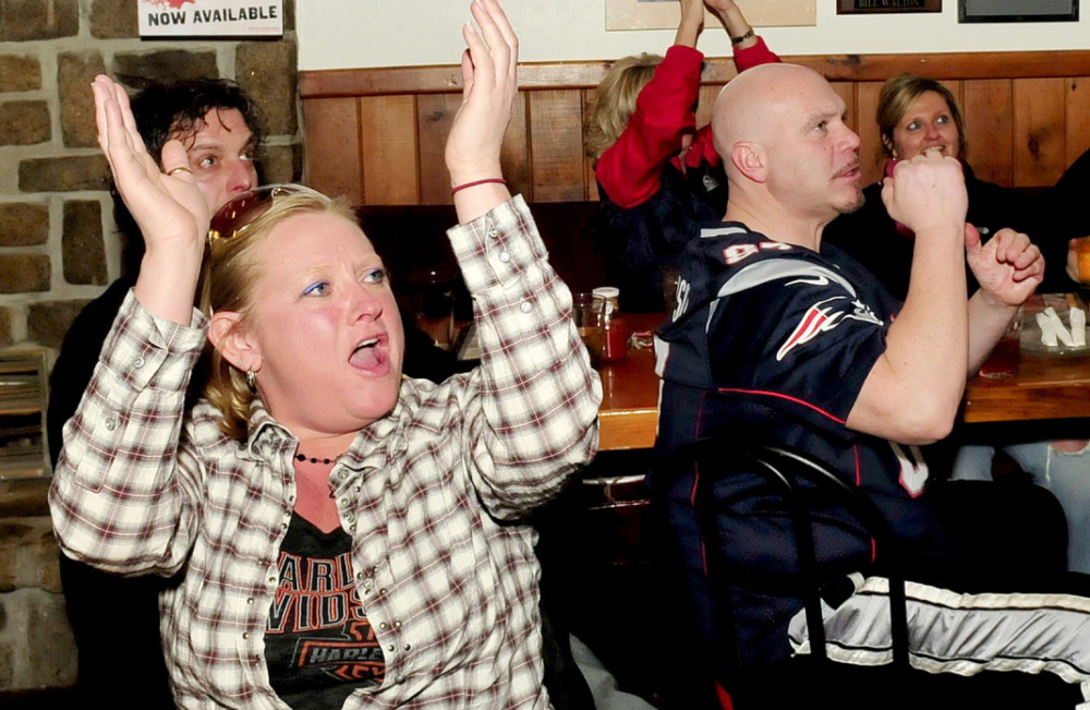 Staff photo by David Leaming GO PATS: New England Patriots fans celebrate a play during AFC championship game against Denver Broncos during first half action at the Pointe Afta restaurant in Winslow on Sunday, jan. 19, 2014. From left are Sammi-Jo MacFarland and Doug Dutton.
