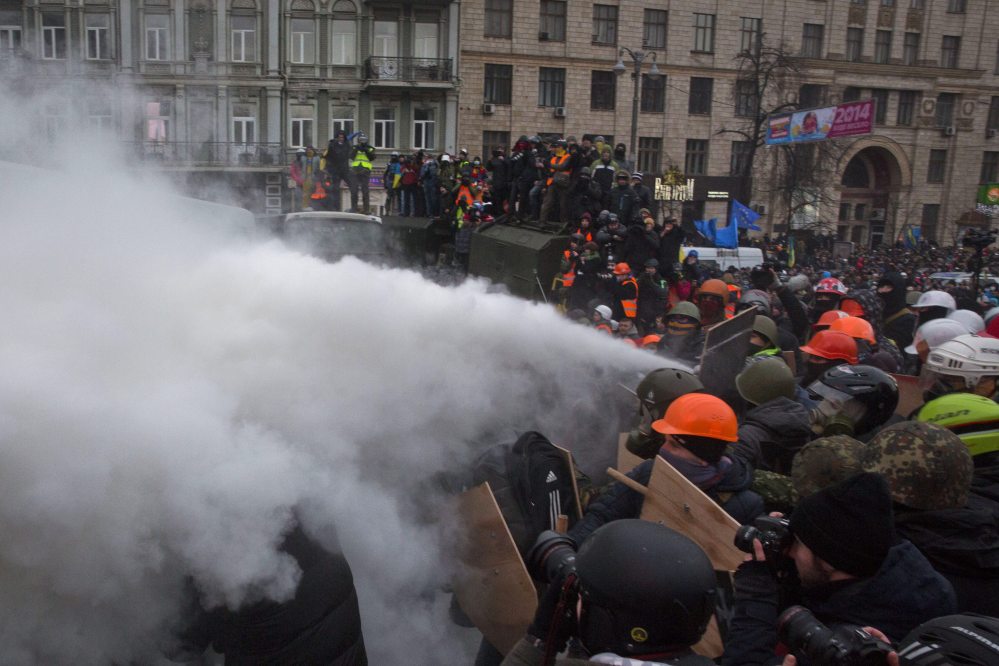 Protesters clash with riot police in central Kiev, Ukraine, on Sunday. Thousands of protesters clashed with riot police in the center of the Ukrainian capital, after the passage of harsh anti-protest legislation last week seen as part of attempts to quash anti-government demonstrations. A group of radical activists began attacking riot police with sticks, trying to push their way toward the Ukrainian parliament building, which has been cordoned off by rows of police and buses