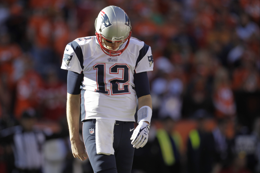 Patriots quarterback Tom Brady walks off the field after the first half of Sunday’s AFC championship game at Denver.