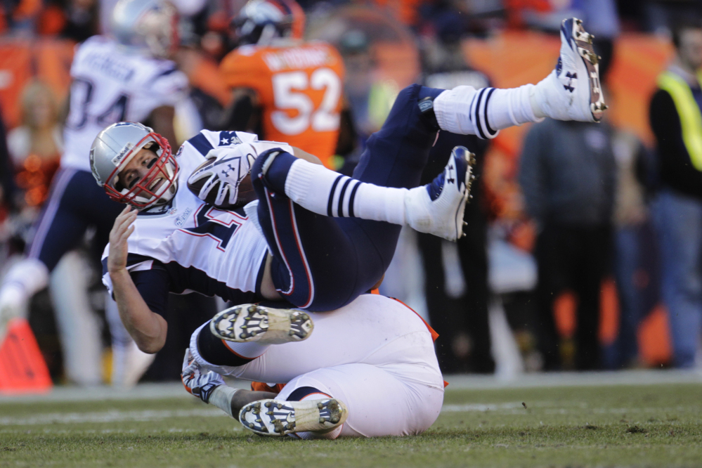 Patriots quarterback Tom Brady is sacked by Broncos defensive end Robert Ayers in the second half Sunday’s AFC championship game at Denver.