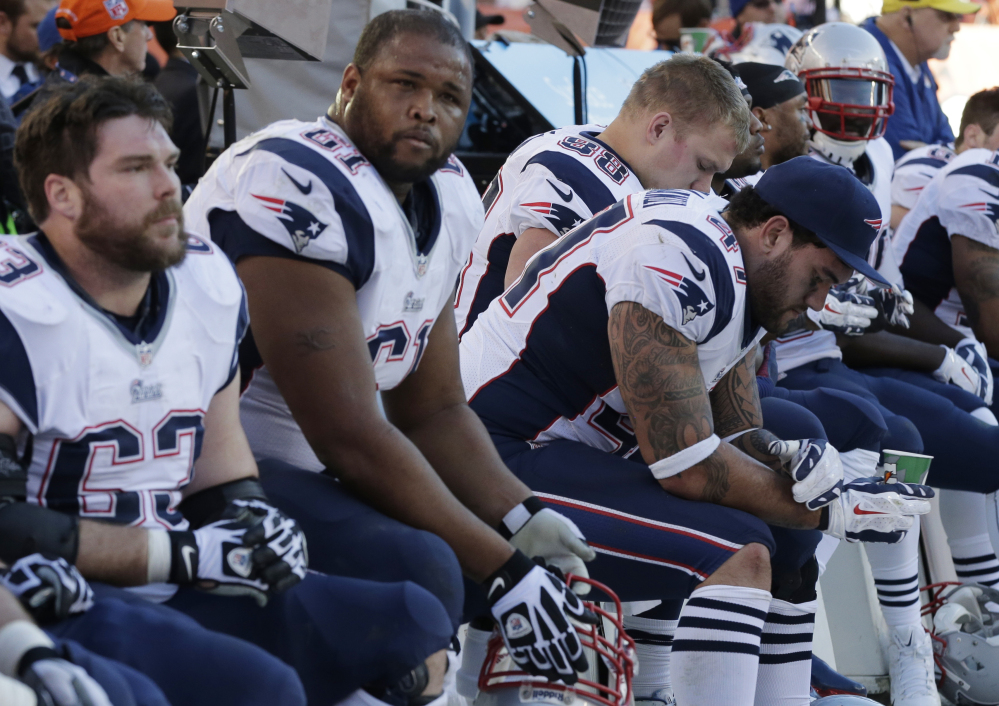 Patriots players on the bench watch the closing minutes of the AFC championship game Sunday at Denver. The Broncos won 26-16 to advance to the Super Bowl.