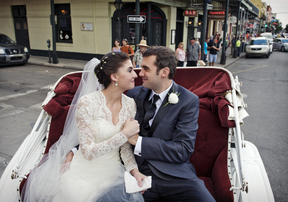 This Oct. 12, 2013 photo provided by Julia Bailey shows Shannon and Justin Peach ride in a carriage after their wedding in New Orleans last October. Shannon’s mother, Cheryl Winter, spent $500 for Hartford-based Travelers Insurance to cover her daughter’s destination wedding, where her biggest concern was a potential hurricane.