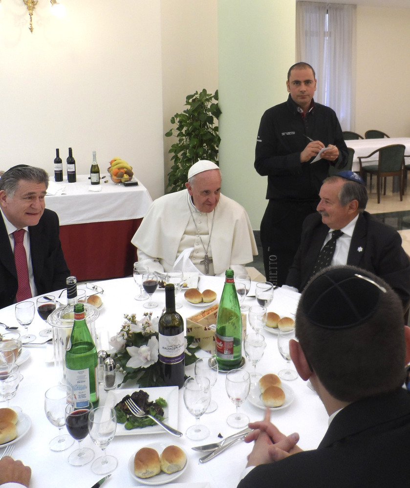 Ba’ Ghetto restaurant co-owner Amit Dabush, top right, takes notes as Pope Francis, center, and Rabbi Abraham Skorka, left, have lunch at the Vatican on Thursday.