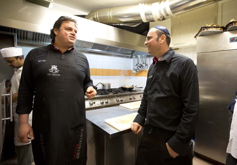 Ba’Ghetto restaurant owners Ilan Dabush, left, and his brother Amit talk in the kitchen of their restaurant in Rome on Monday. Their restaurant catered a four-course luncheon hosted by Pope Francis last week for a dozen Argentine rabbis.