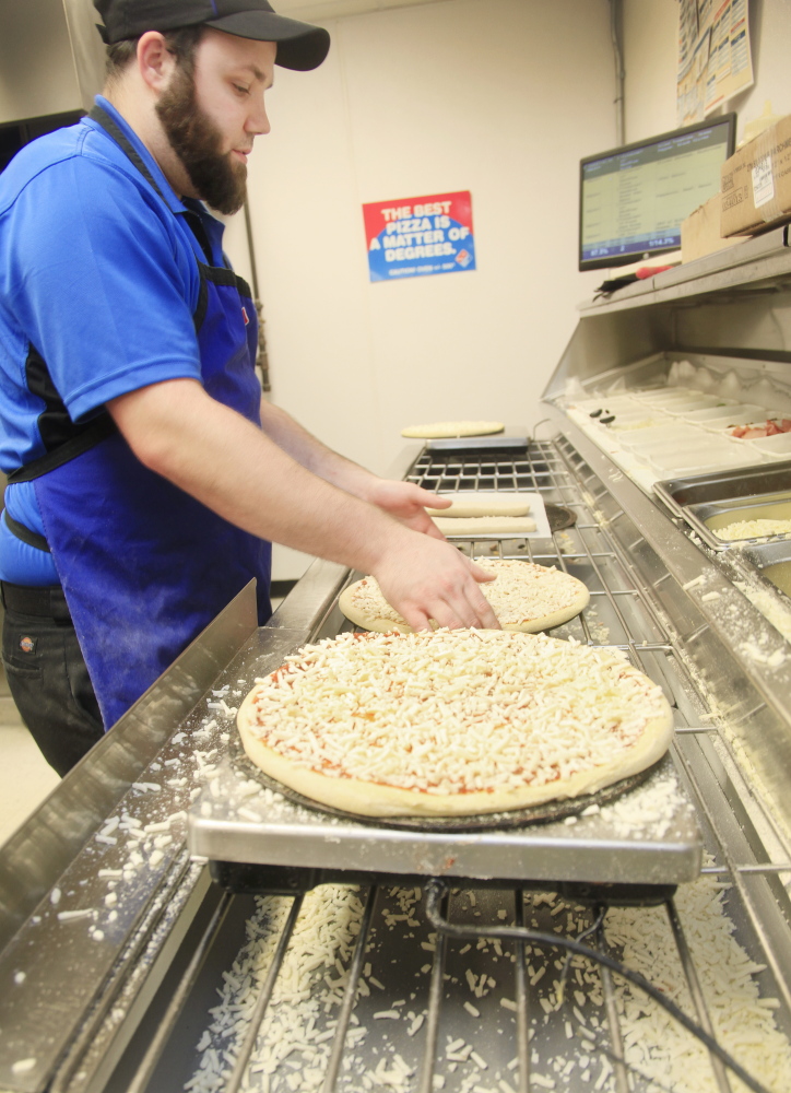 Andrew Legere makes pizzas at Domino’s in Standish.