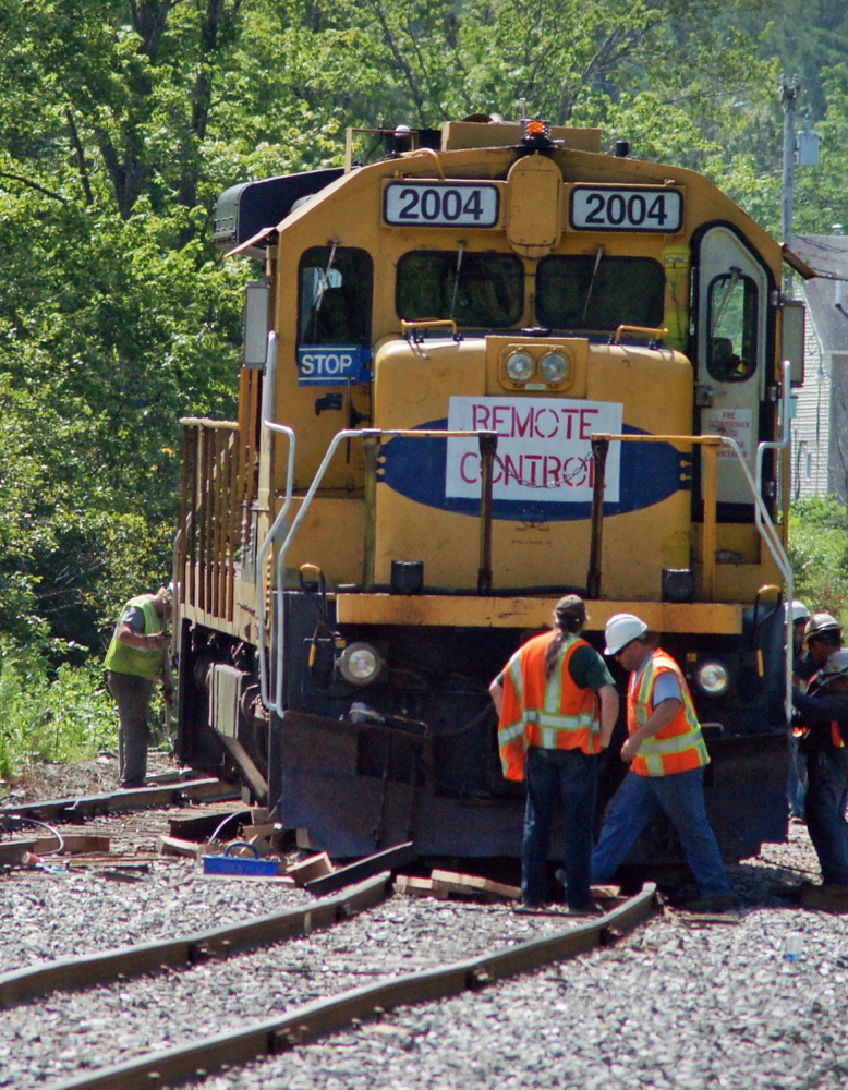 A crew from Montreal, Maine & Atlantic Railway repairs tracks in Brownville in July. The railway was auctioned Tuesday.