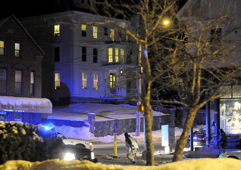 Armed police run in front and stand by on right overlooking the frat house in background during the standoff at USM in Gorham. Wed., January 22, 2014. John Patriquin/Staff Photographer.