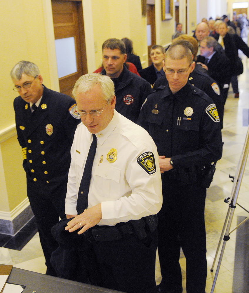 Presque Isle Chief of Police Matthew Irwin is flanked by firefighters from his community Wednesday as he signs up to testify on potential cuts by the state to municipal aid. Cops, firefighters and town officials lined up to testify on the bill that would avoid a $40 million cut in municipal revenue sharing.