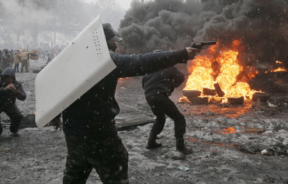 A protester points a handgun during a clash with police in central Kiev, Ukraine, Wednesday.