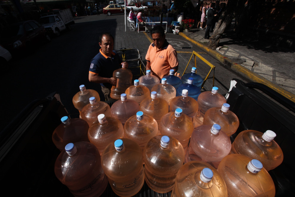 A vendor prepares to fill his bicycle cart with 18-liter jugs of bottled water to sell to owners of street food stalls in Mexico City.