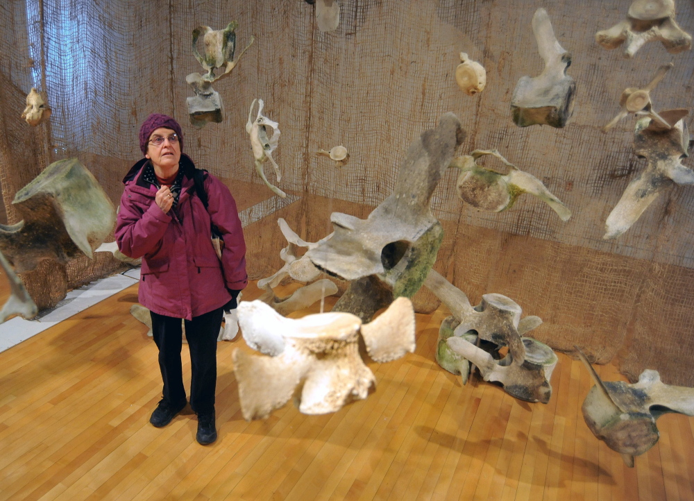 WHALE REMNANTS: Vici Robinson, of Kingfield, pauses for a moment Friday as she walks through an interactive hands-on exhibit featuring whale bones from whales native to the Gulf of Maine in the Flex Space at the Emery Community Arts Center at the University of Maine at Farmington.