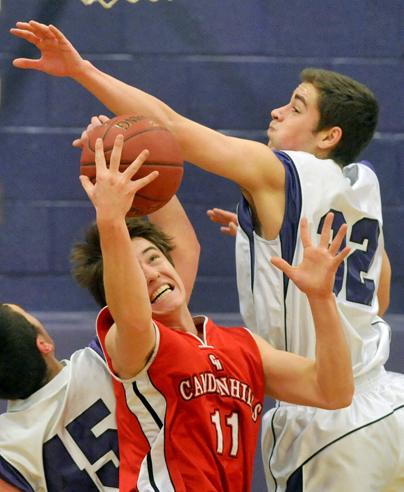 Staff photo by Michael G. Seamans Camden Hills High School's Chandler Crans, 11, center, fights for the loose ball with Waterville Senior High School's Benjamin Cox, 45, left, and Owen Brown, 32, in the third quarter in Waterville on Friday. Waterville defeated Camden Hills 62-56.