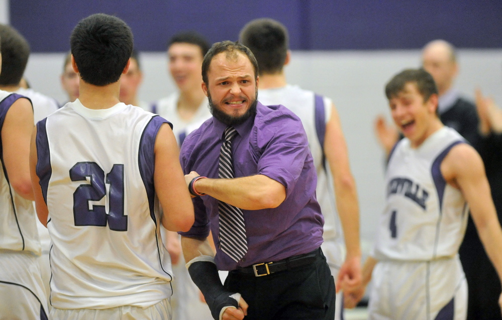 Staff photo by Michael G. Seamans Waterville Senior High School head coach Wade Morrill celebrates with his players after defeating Camden Hills High School 62-56 in Waterville on Friday.
