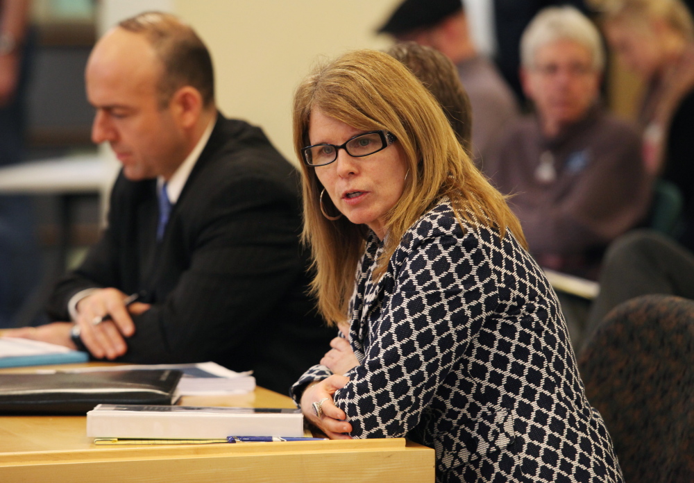 Mary Mayhew, commissioner of the Maine Department of Health and Human Services, shown at a meeting Tuesday in Augusta, says the department has revised its budget shortfall estimate from $108 million to $78 million.