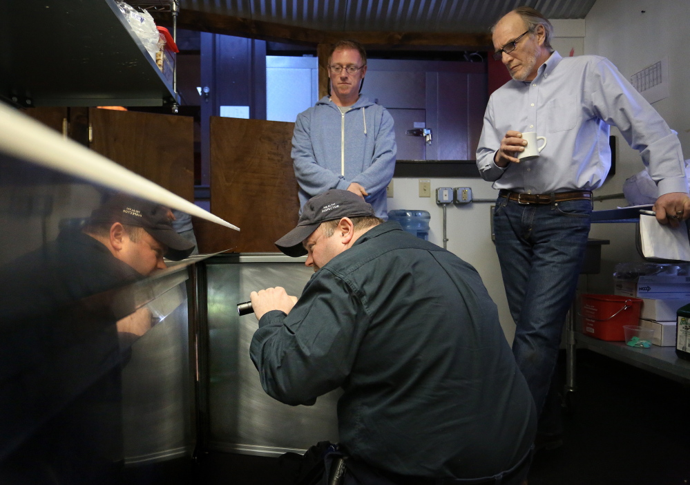 Portland Health Inspector Tom Williams, front, inspects the kitchen of Buck’s Naked BBQ on Wharf Street on Friday. Watching are restaurant owner Alex Caisse, left, and Al Brown, operations manager. Portland is one of just five communities allowed to conduct its own inspections.This caption was updated at 7 p.m. Sunday, Jan. 26, to correct the name of the owner of Buck's Naked BBQ.