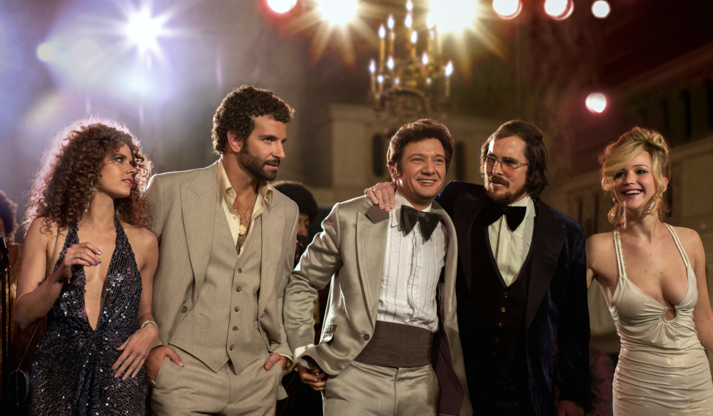 This film image released by Sony Pictures shows, from left, Amy Adams, Bradley Cooper, Jeremy Renner, Christian Bale and Jennifer Lawrence in a scene from “American Hustle.”
